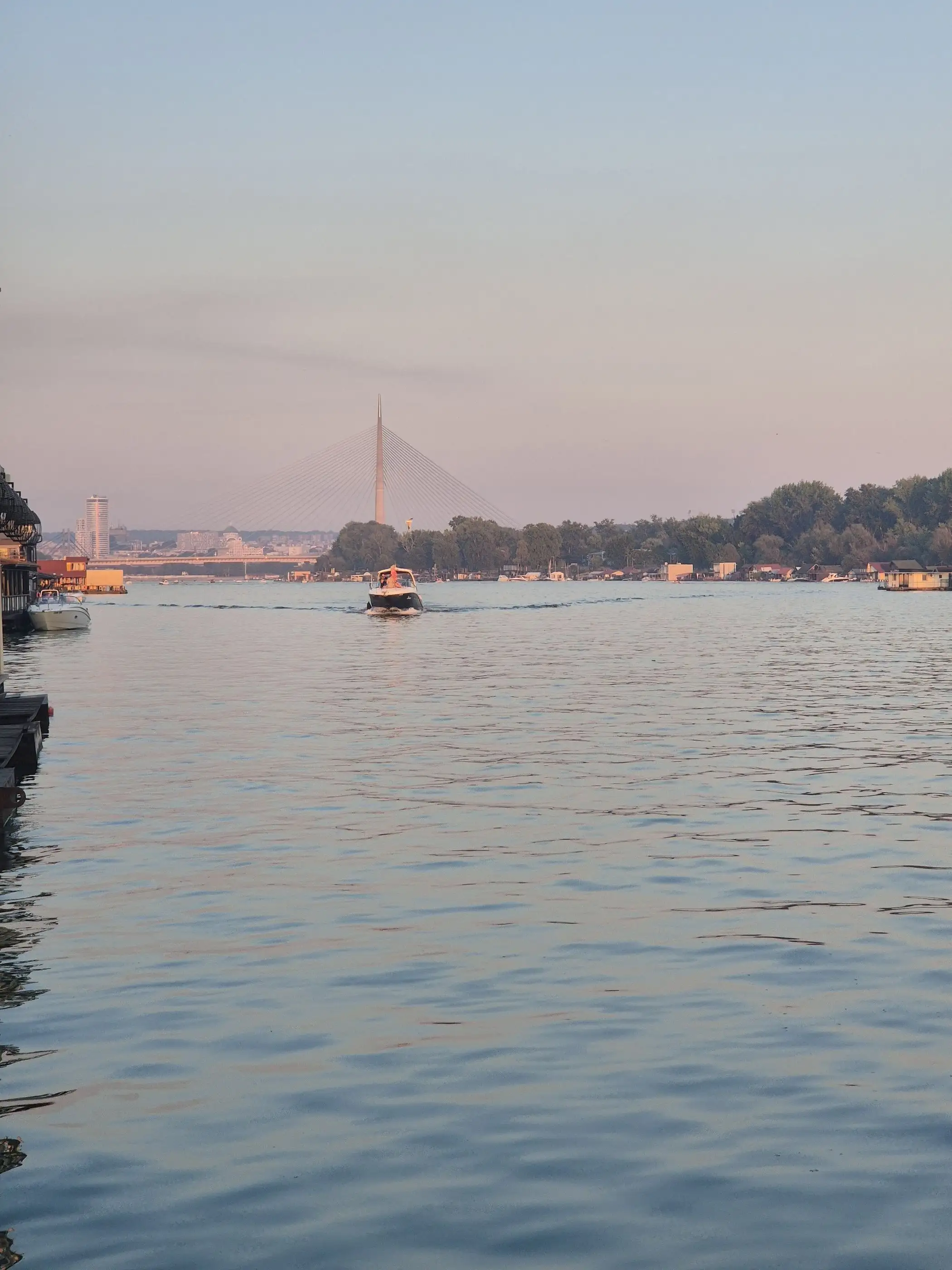 Sava u sumrak sa splava Bahus, u daljini Most na Adi